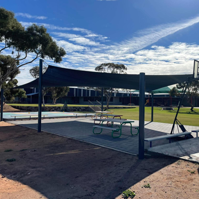 Shade sail covering an outdoor play and learning area at a school