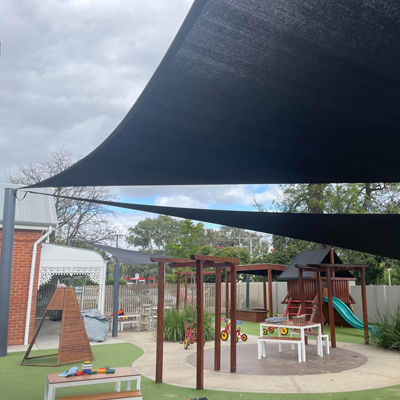 Commercial shade sail providing sun protection over a preschool outdoor area